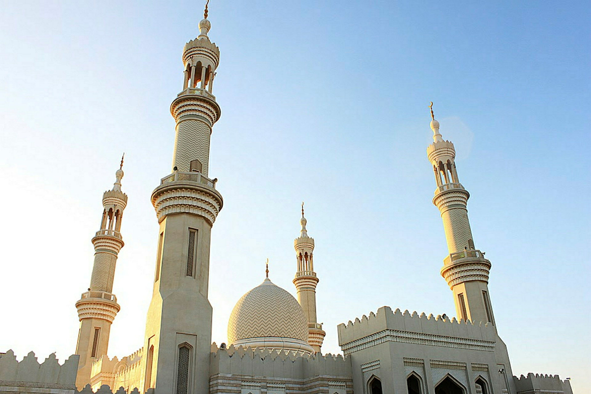 En moské med flera minareter mot en klar himmel. (AI-genererad text)