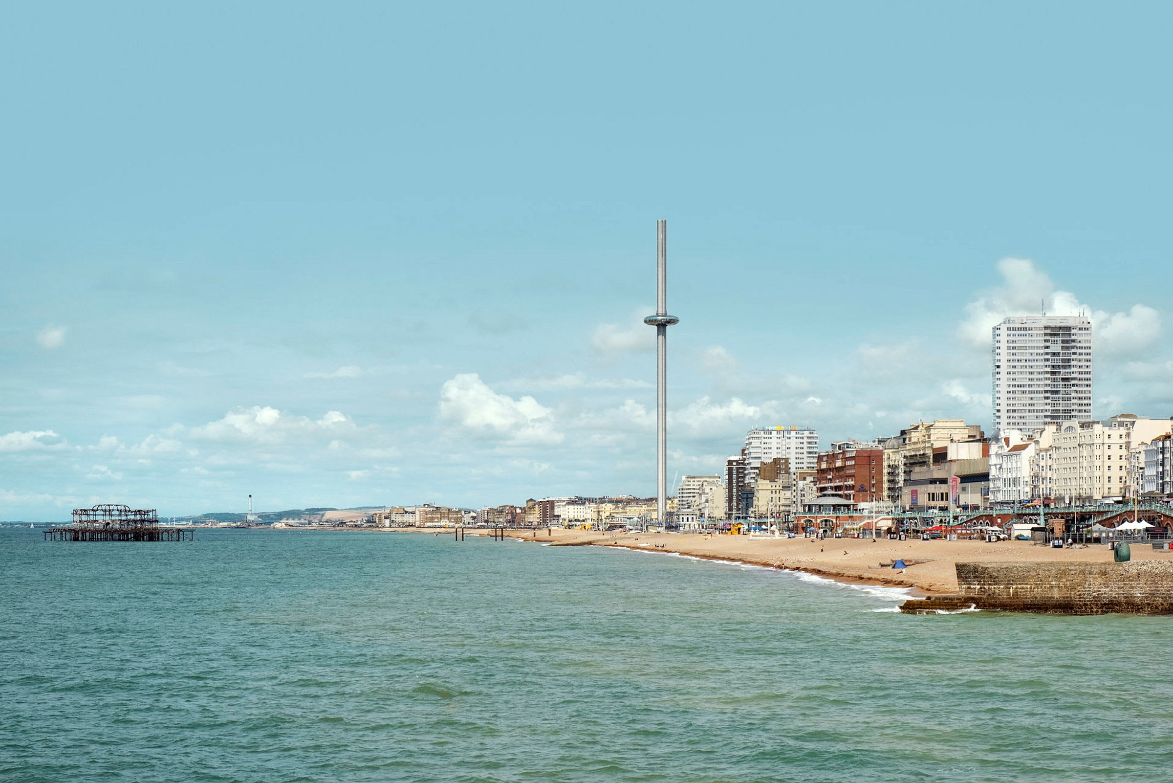 Utsikt över havet och strand vid Brighton med i360 tornet och byggnader i bakgrunden. (AI-genererad text)
