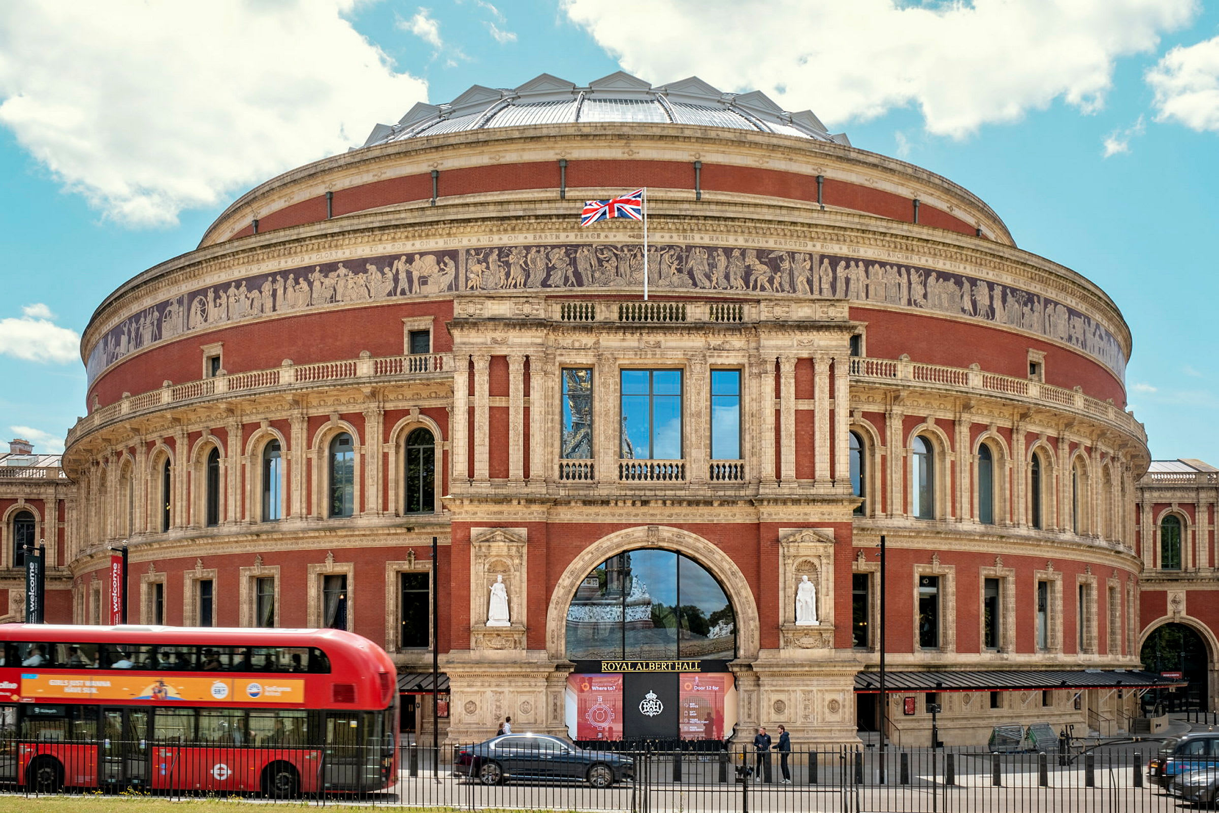 En bild av Royal Albert Hall i London, med en röd buss i förgrunden. (AI-genererad text)