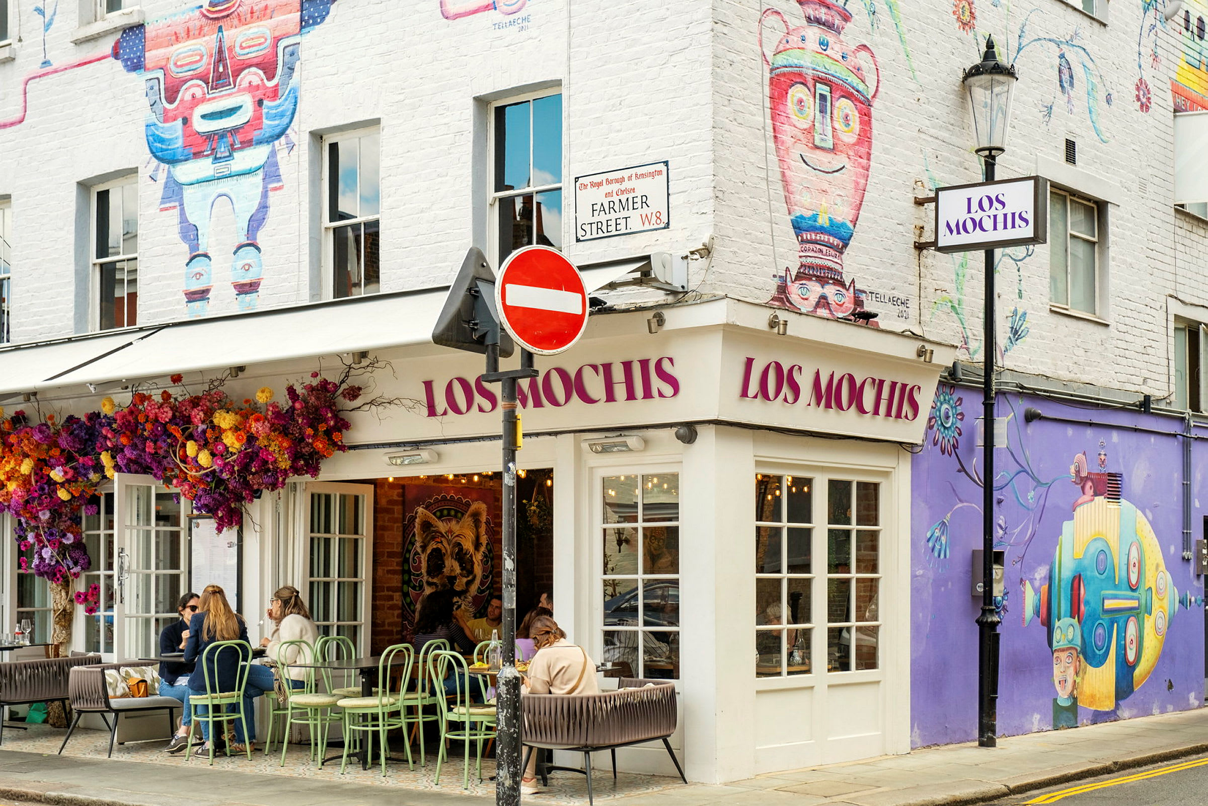 Restaurang med namnet Los Mochis, dekorerad med färgglada väggmålningar och blommor. (AI-genererad text)