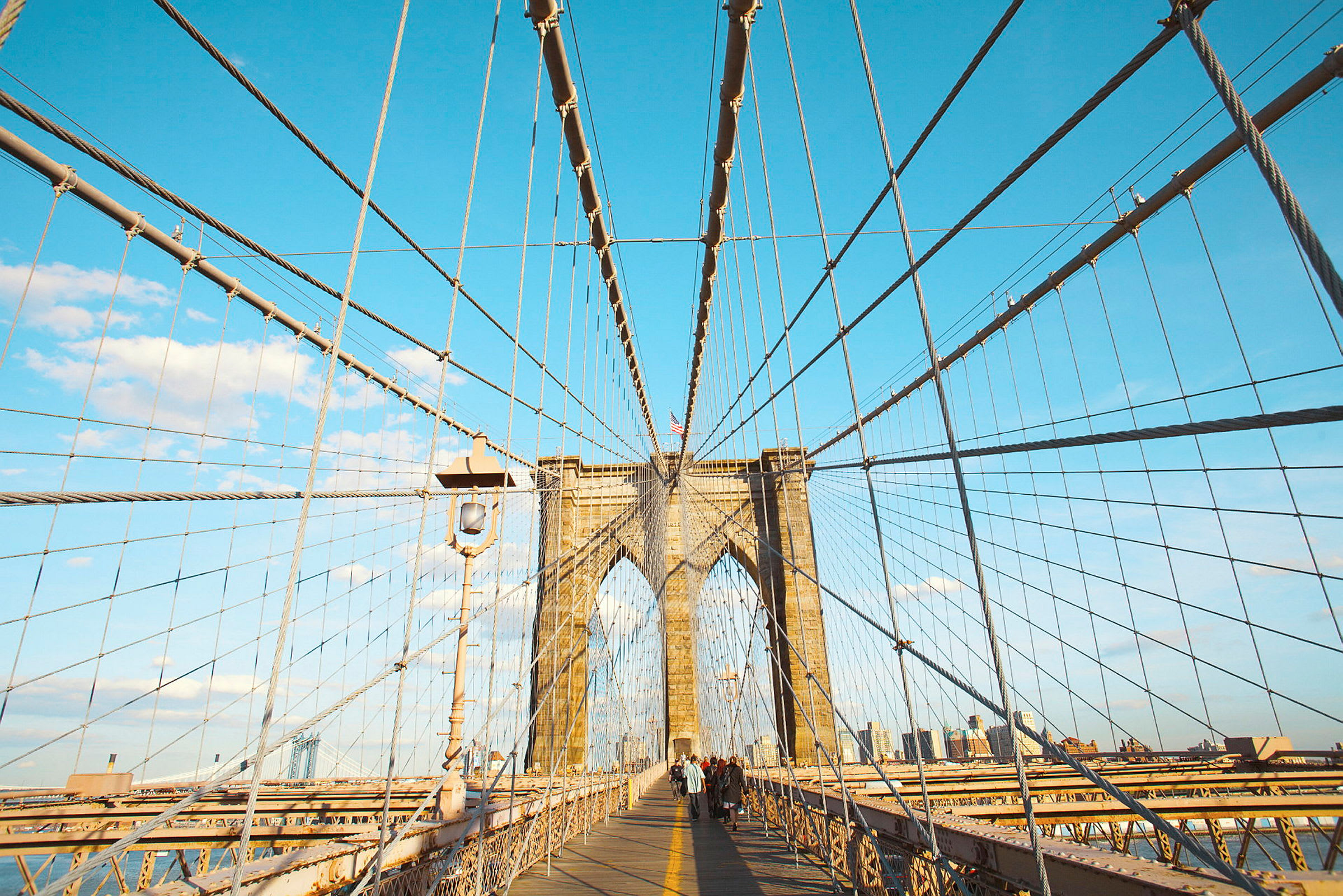 Brooklyn Bridge med vajrar och personer som promenerar på gångvägen. (AI-genererad text)