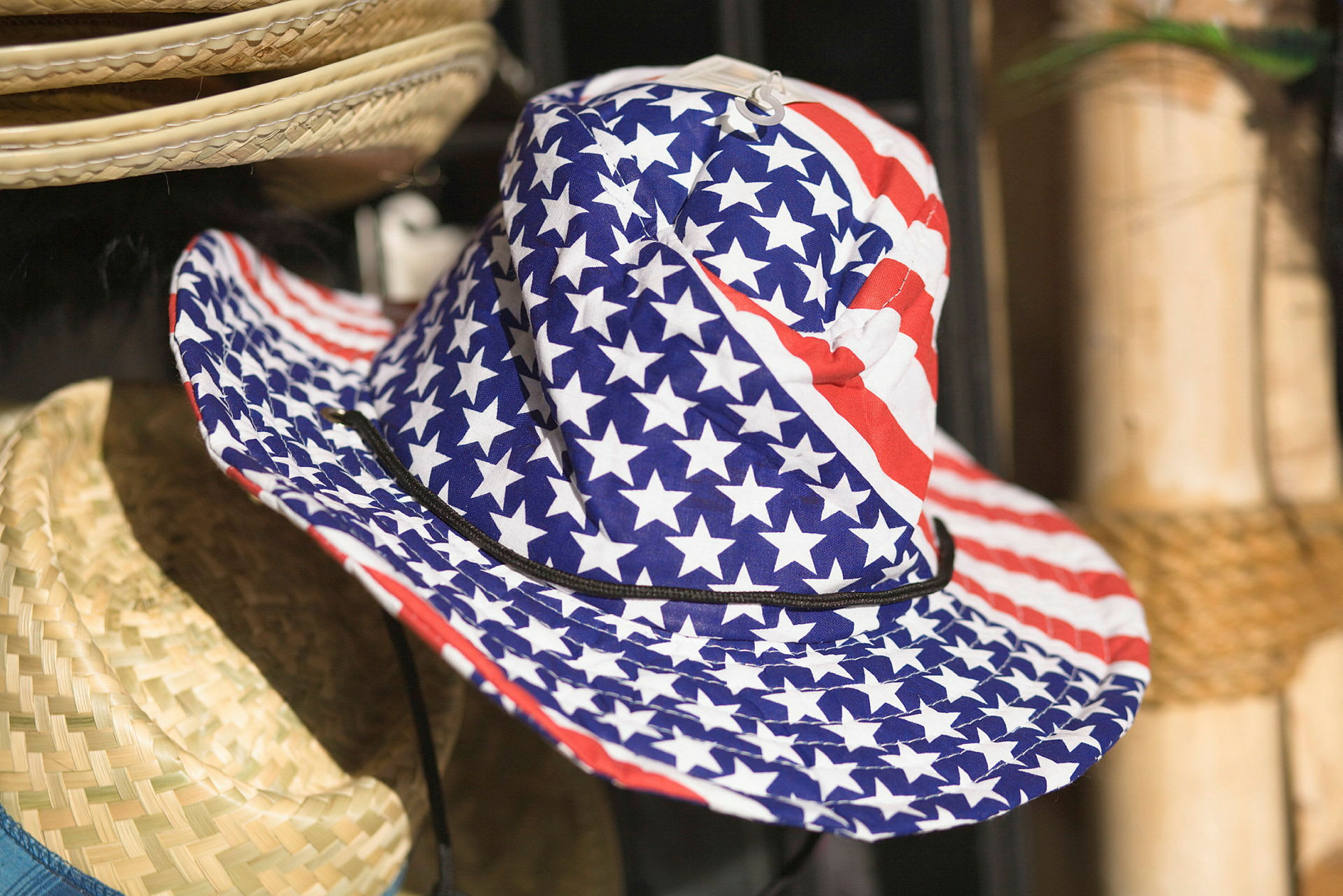 En hatt med ett mönster av amerikanska flaggan hänger bredvid andra hattar. (AI-genererad text)