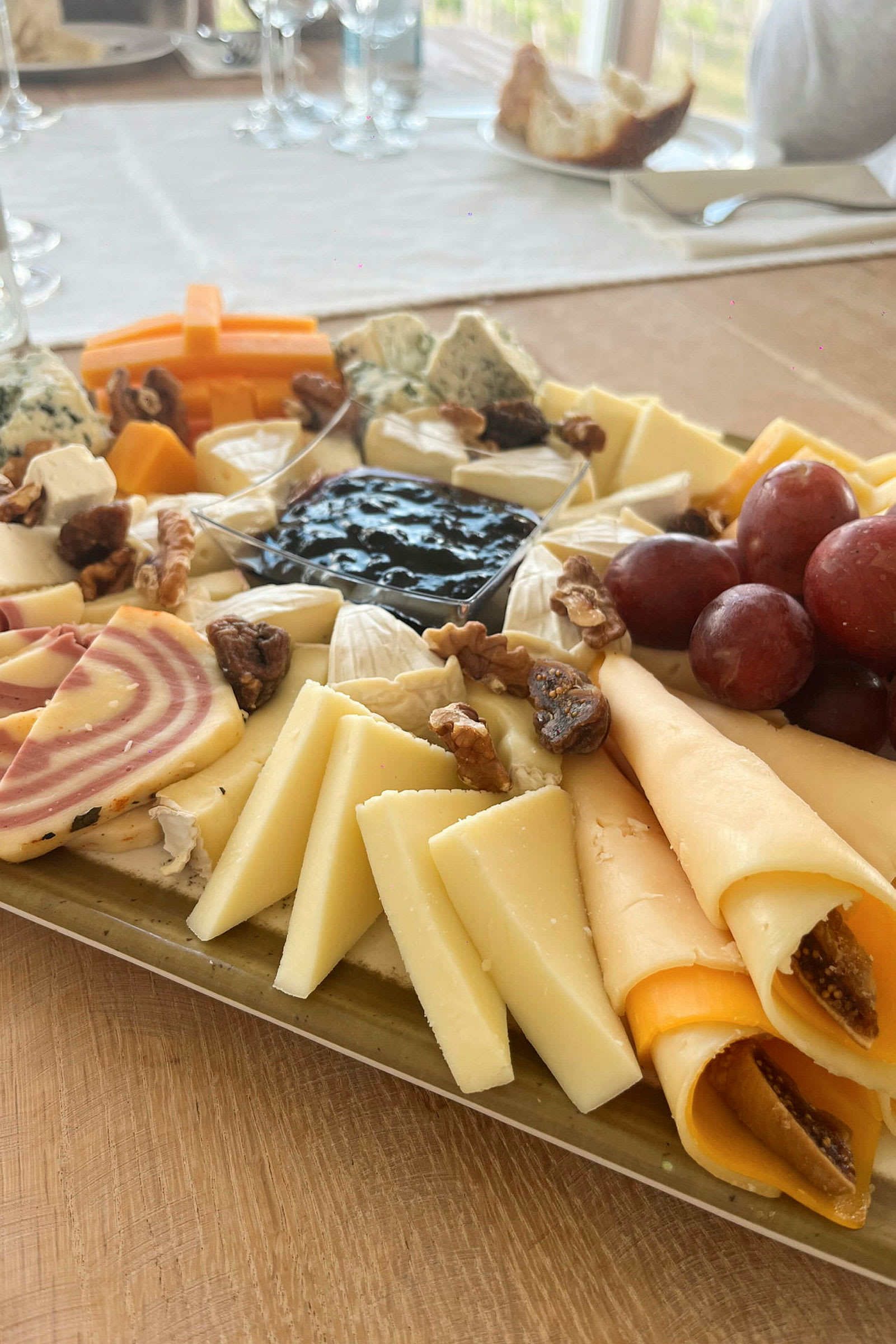 En bricka med olika sorters ost, frukt och nötter. (AI-genererad text)