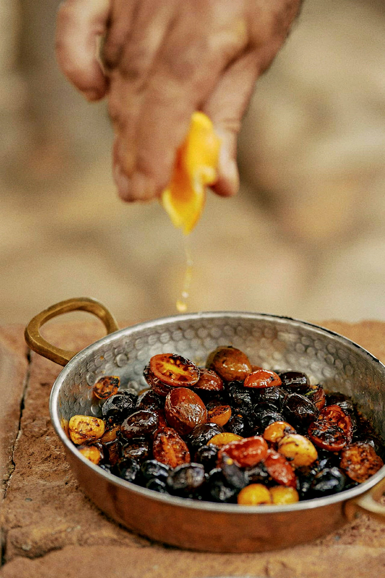 Hand pressar citronsaft över grönsaker i en kopparpanna. (AI-genererad text)