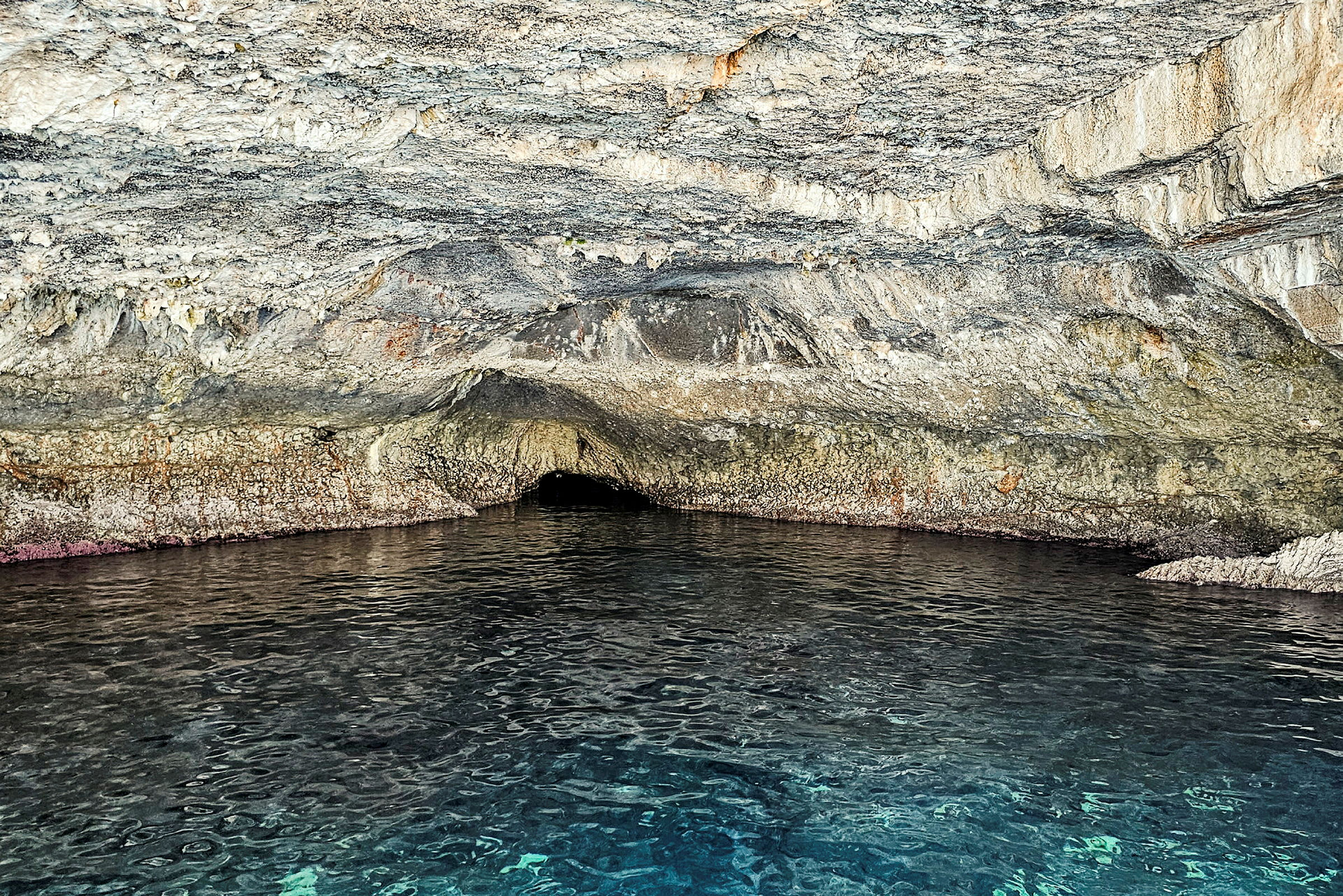 Bild av en grotta med ingång över vattenytan. (AI-genererad text)