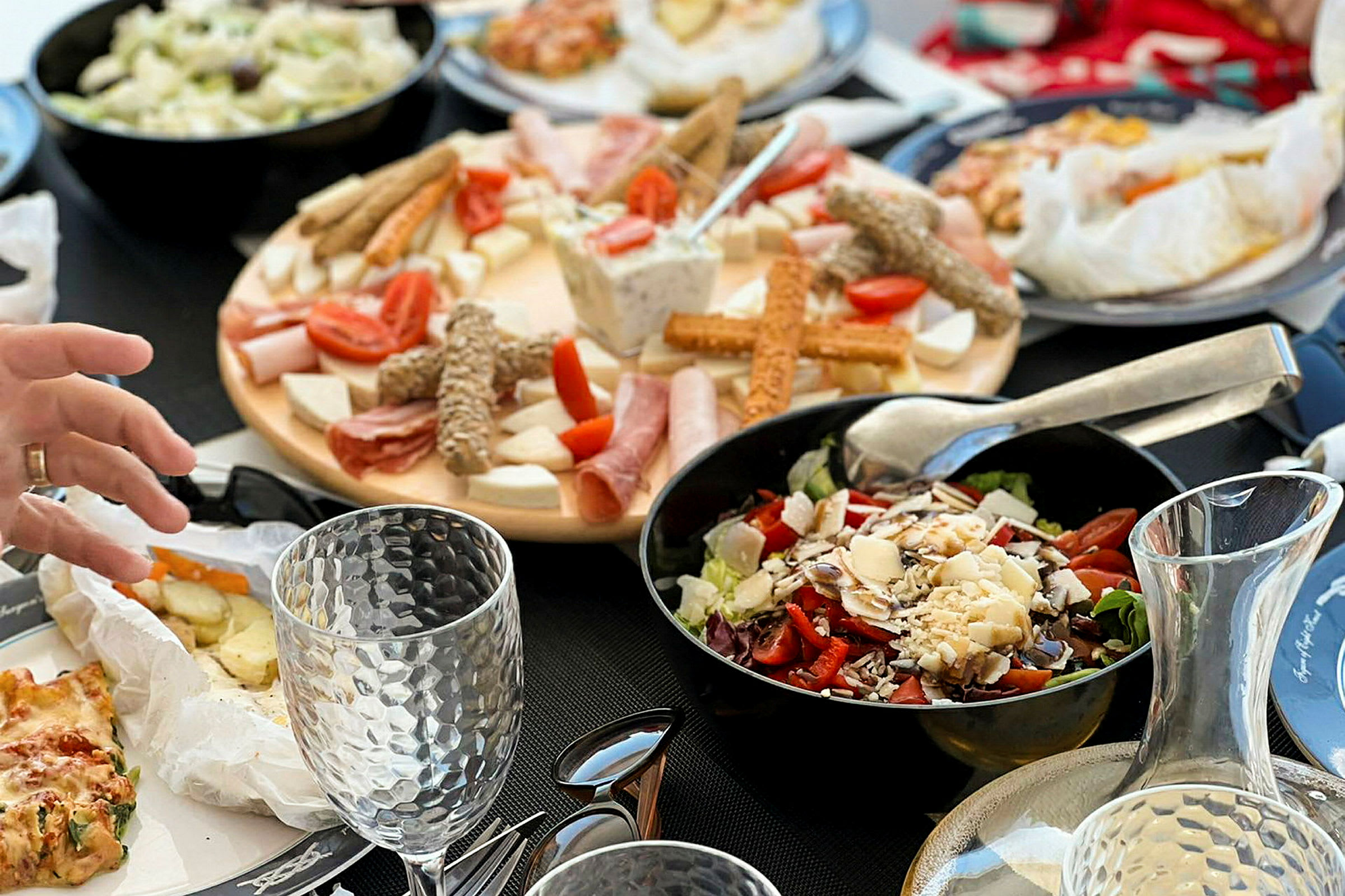 Ett bord dukat med olika maträtter, bland annat sallad, kallskuret och kex. (AI-genererad text)