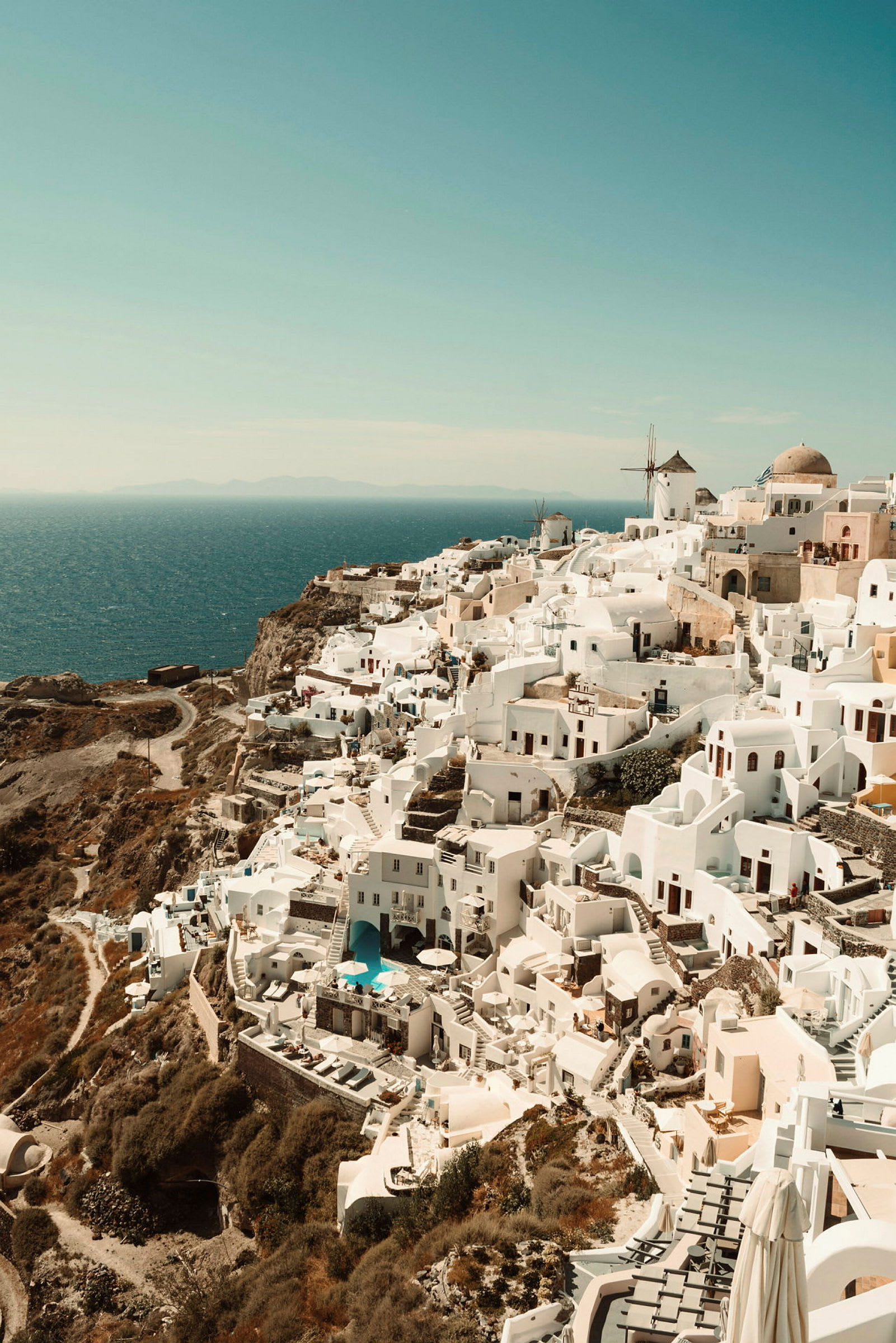 Utsikt över vita hus och byggnader på en klippa vid havet, typiskt för Santorini. (AI-genererad text)