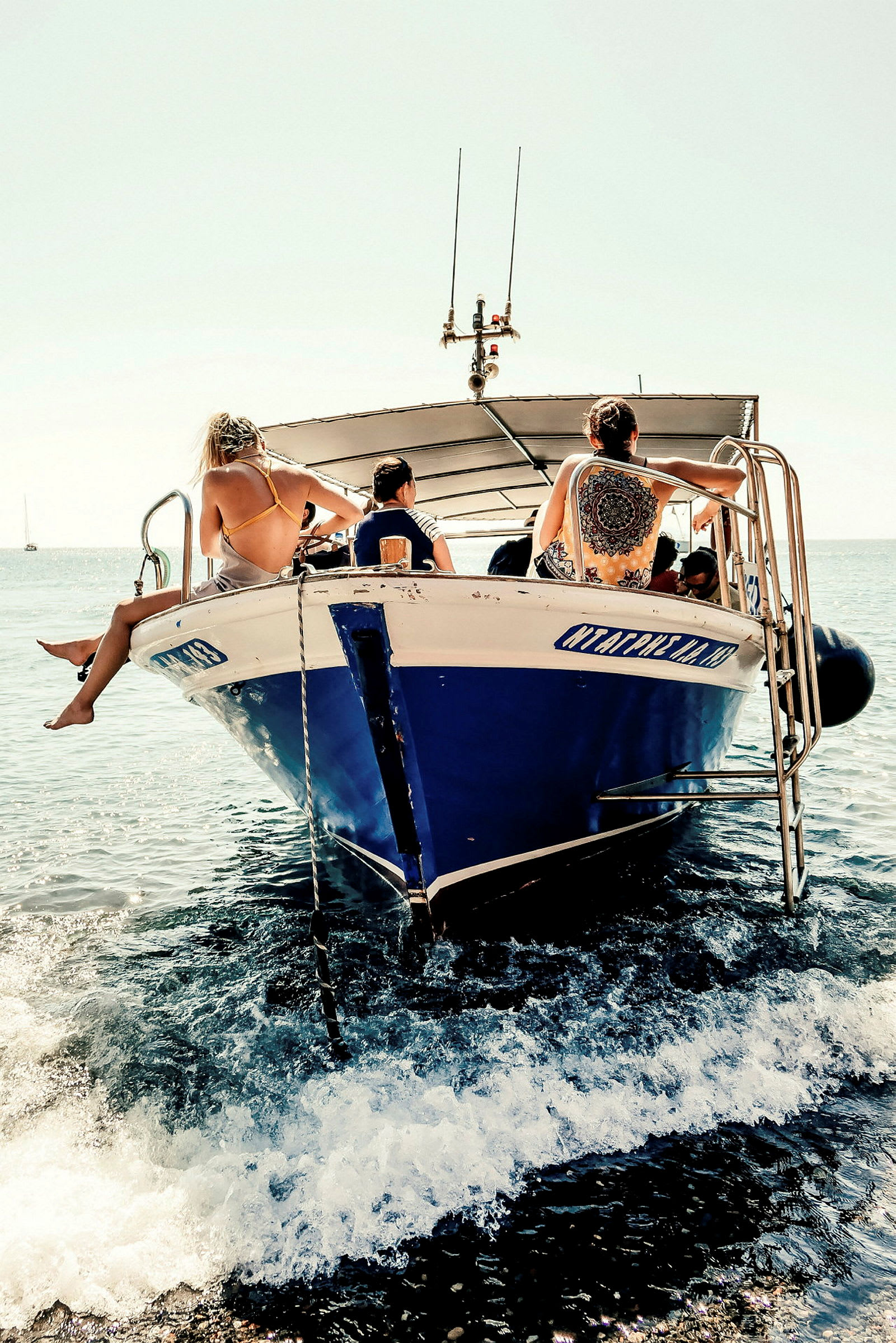 En motorbåt med människor som sitter på dess främre del i havet. (AI-genererad text)