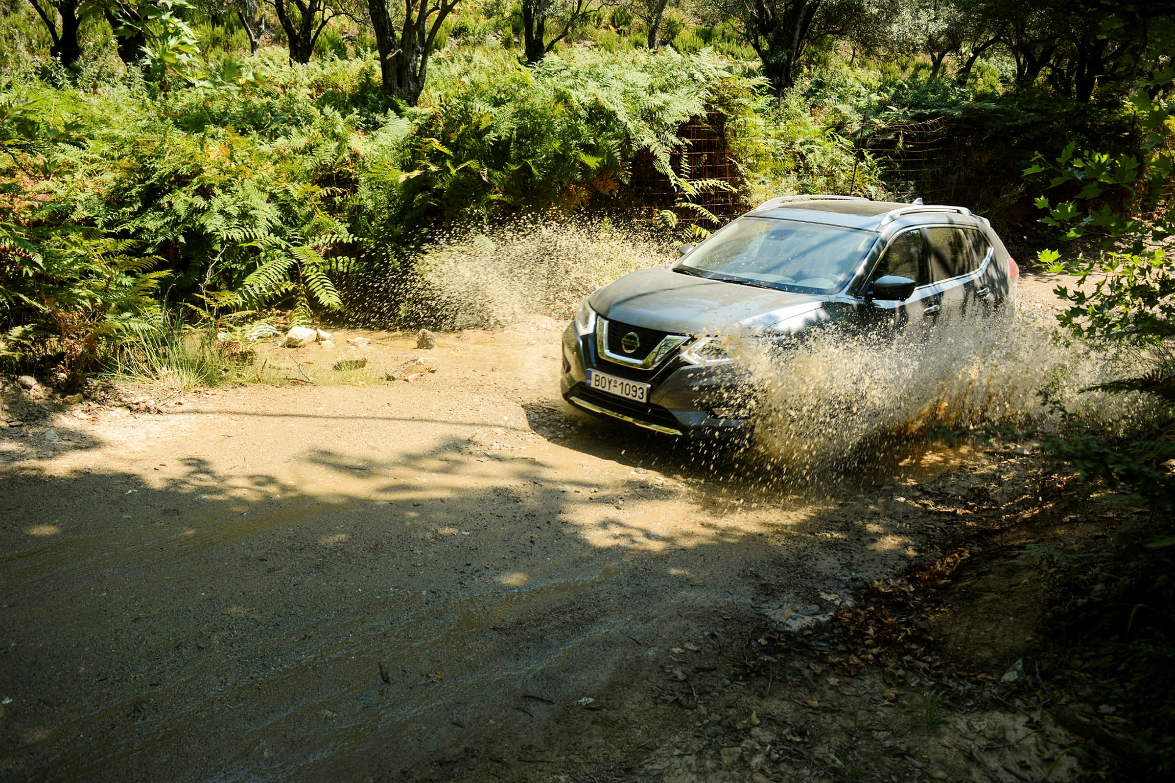 En SUV kör genom en vattenpöl omgiven av frodig vegetation. (AI-genererad text)