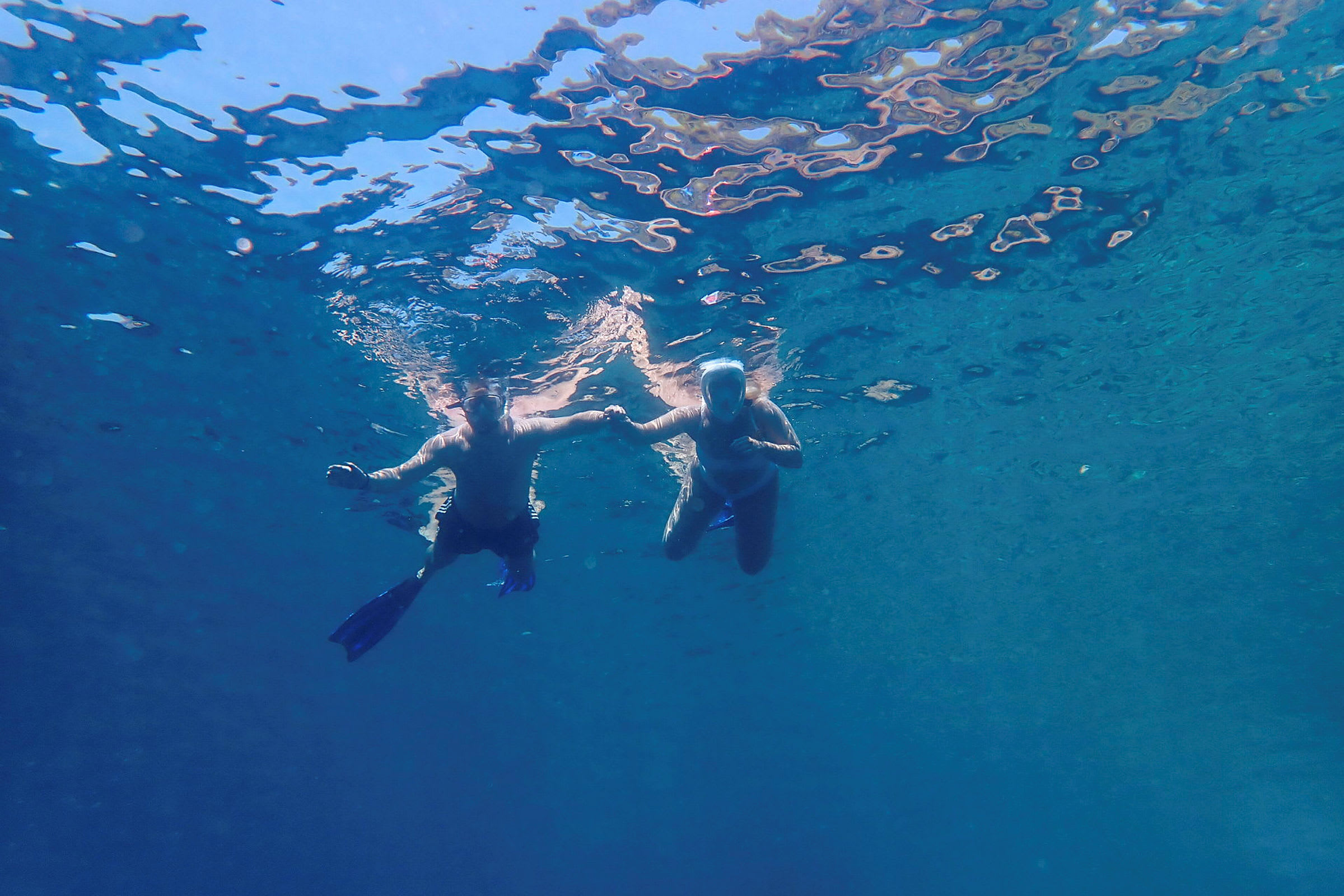 Två personer som snorklar under vattenytan. (AI-genererad text)
