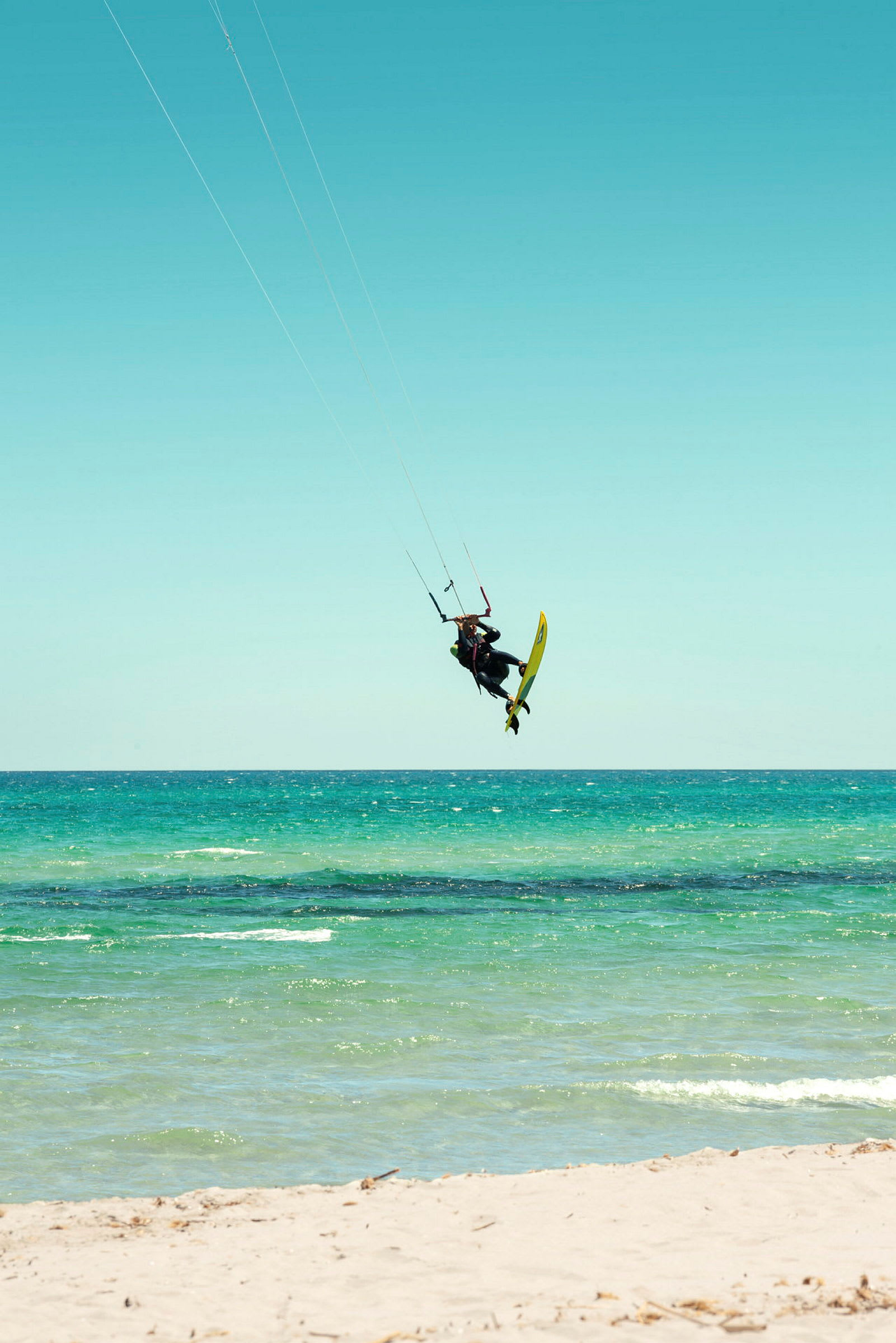 Person kitesurfar på ett blågrönt hav. (AI-genererad text)