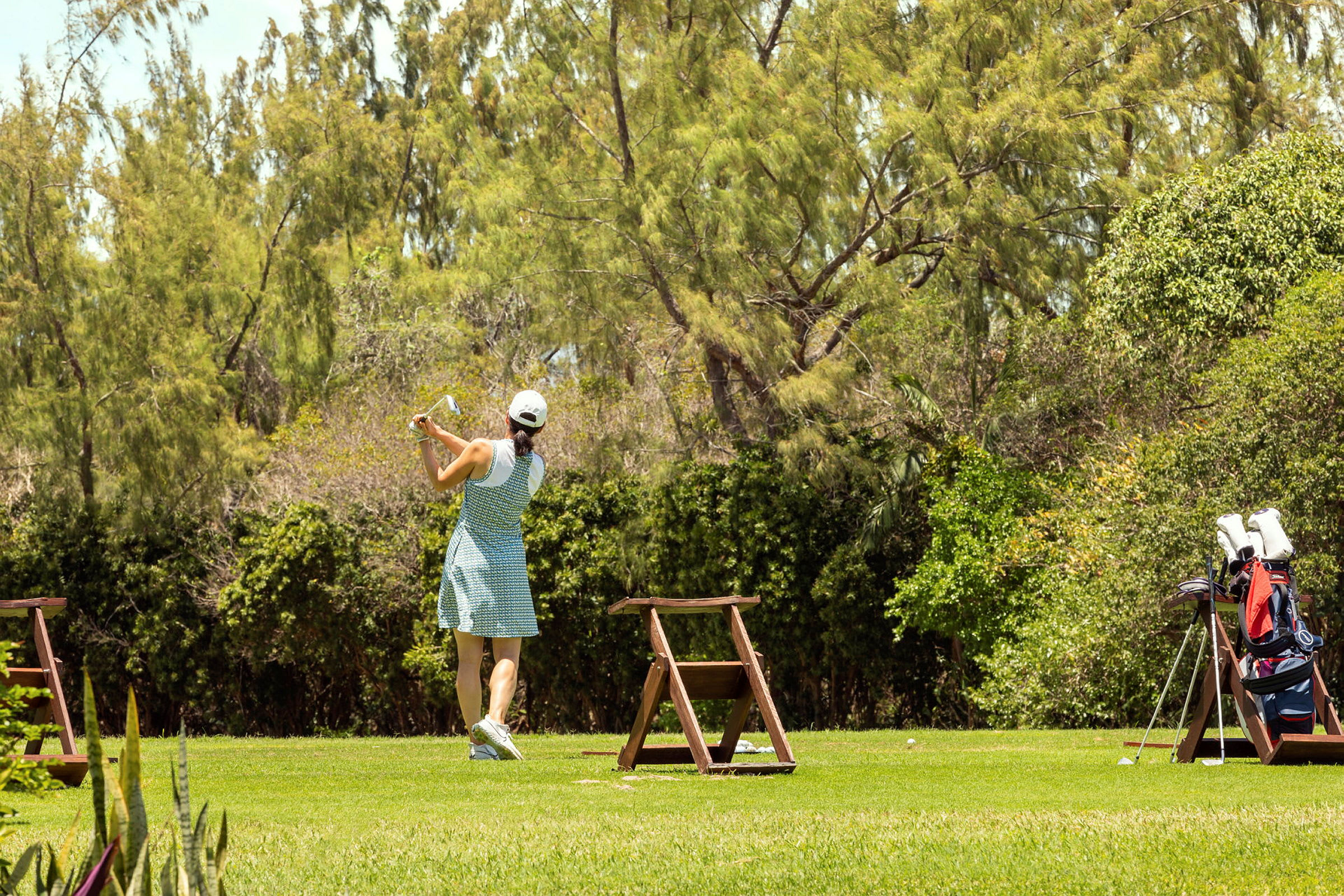En person som spelar golf på en grönområde. (AI-genererad text)