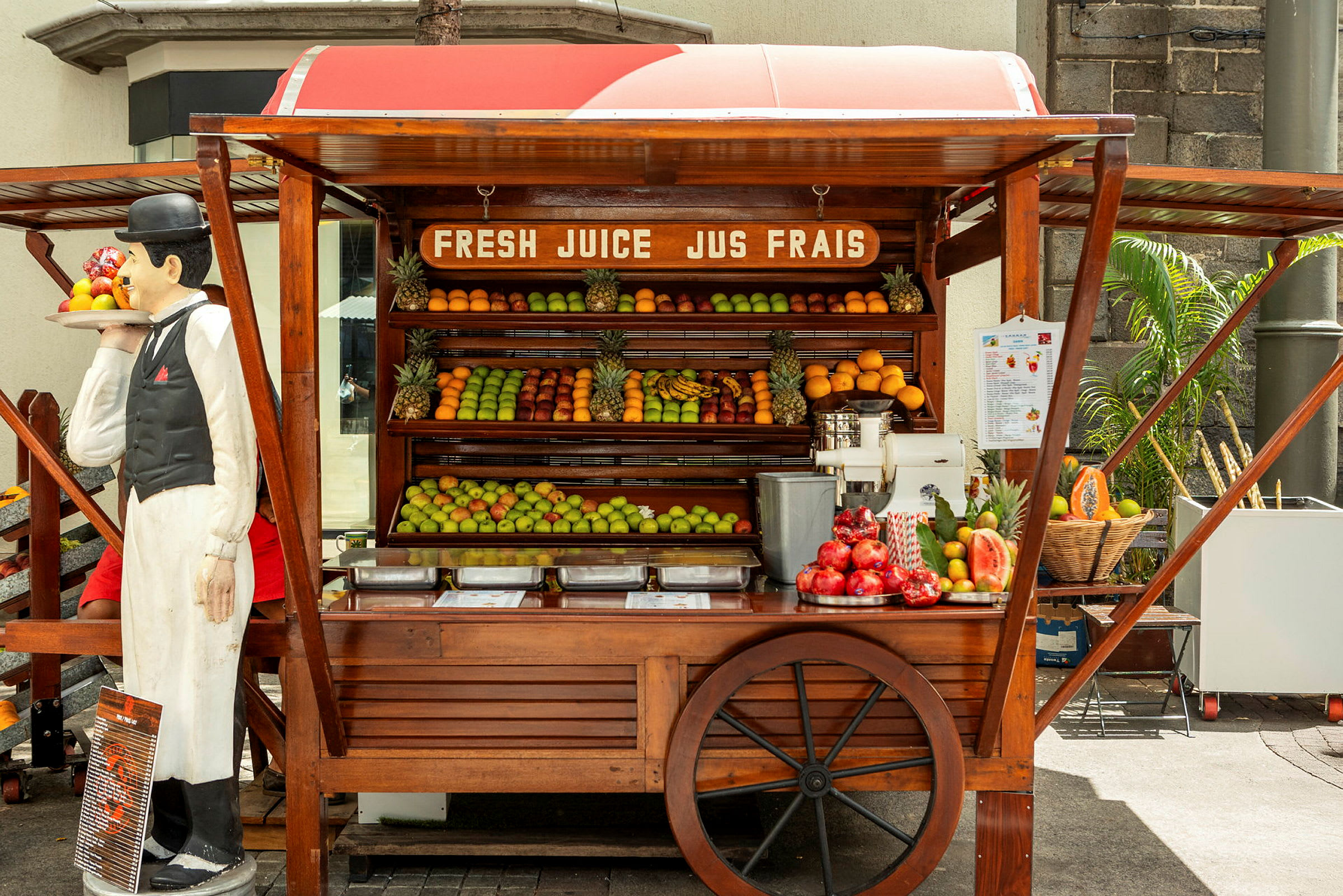 Ett fruktstånd med färska frukter och en juicepress. (AI-genererad text)