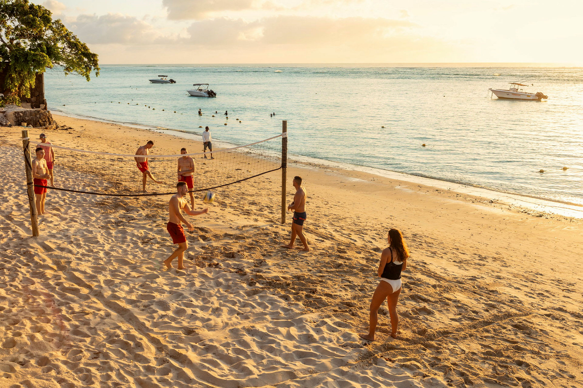 Personer spelar volleyboll på en sandstrand vid havet. (AI-genererad text)