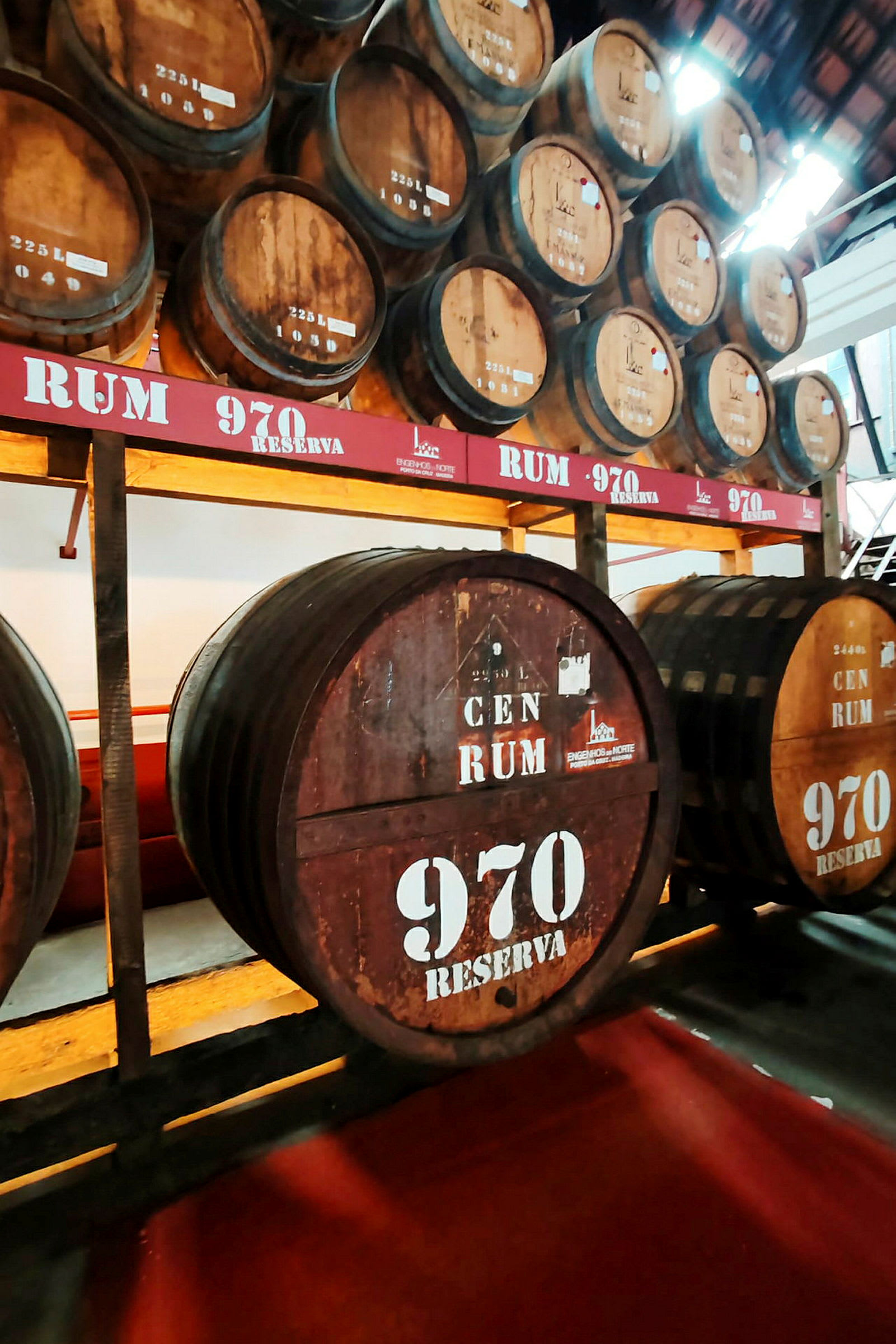 Flera stora träfat på en lagringshylla, märkta med texten 'Rum 970 Reserva'. (AI-genererad text)