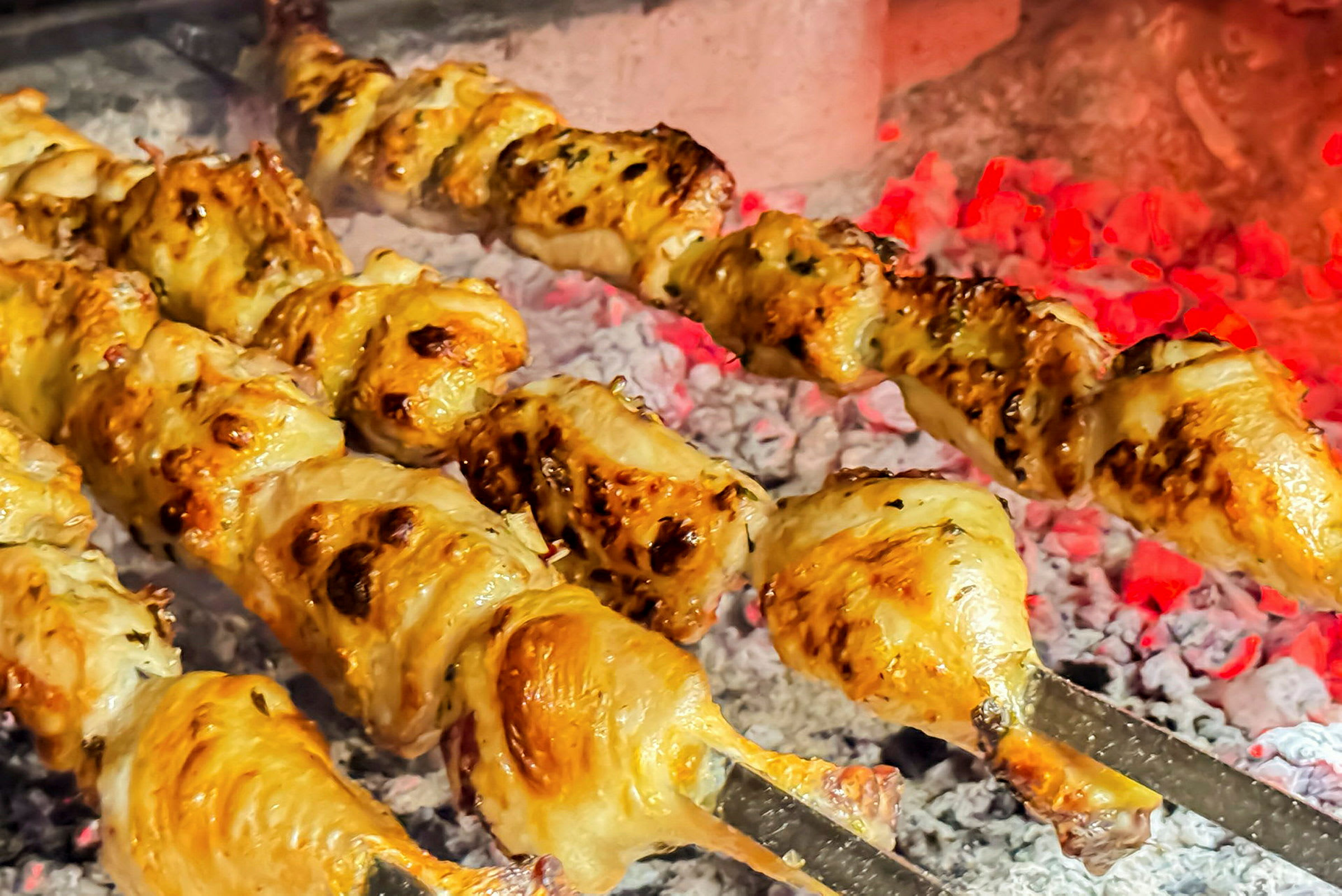 Grillad kyckling på spett över glödande kol. (AI-genererad text)