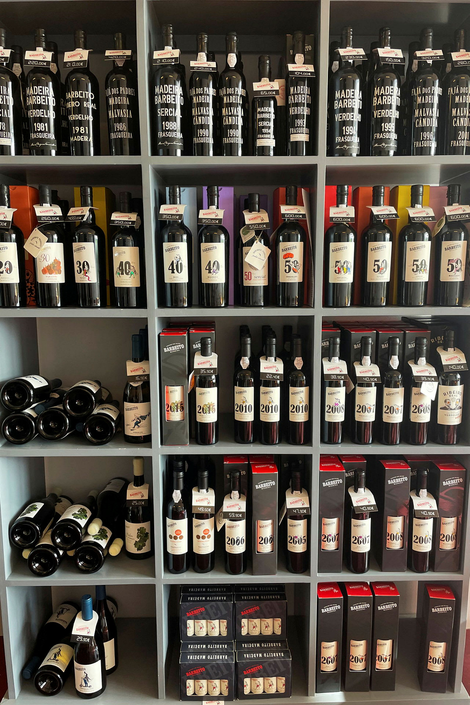 En hylla med flaskor av vin och andra drycker. (AI-genererad text)