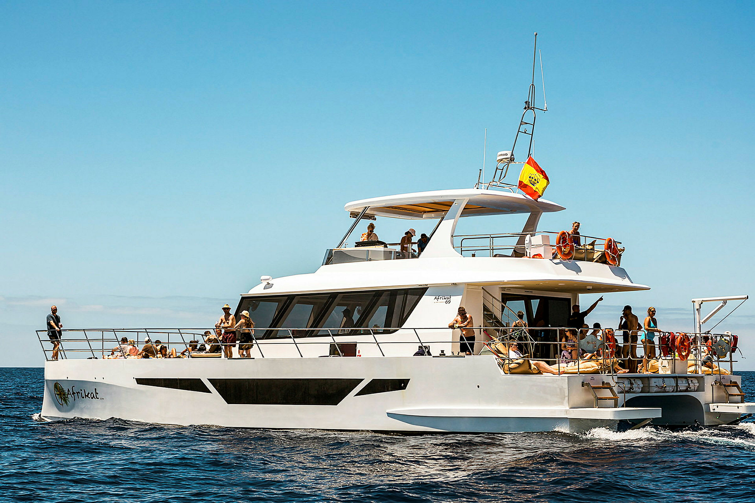 En vit motorbåt med människor som njuter av en solig dag på havet. (AI-genererad text)