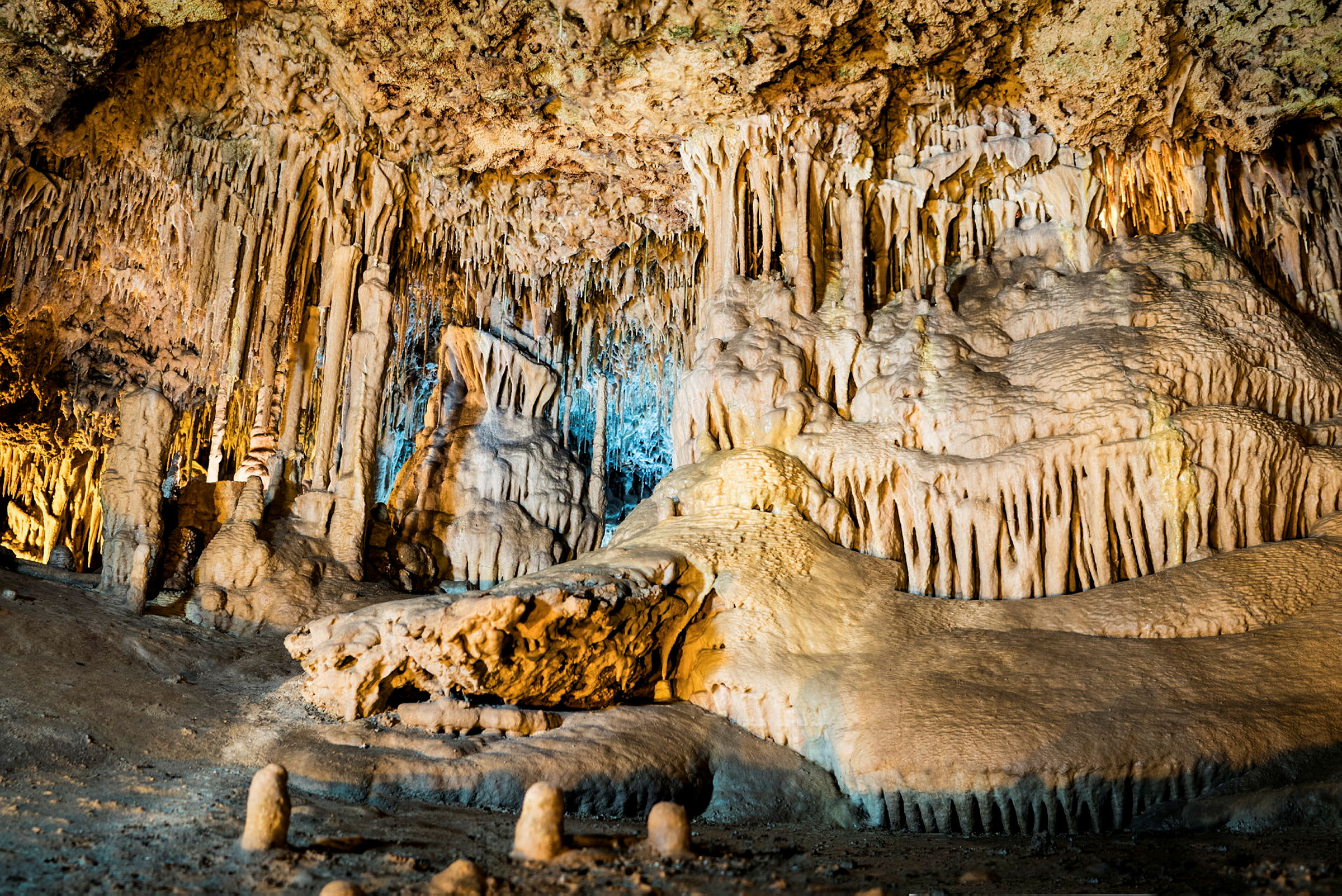En bild av en kalkstensgrotta med stalaktiter och stalagmiter. (AI-genererad text)