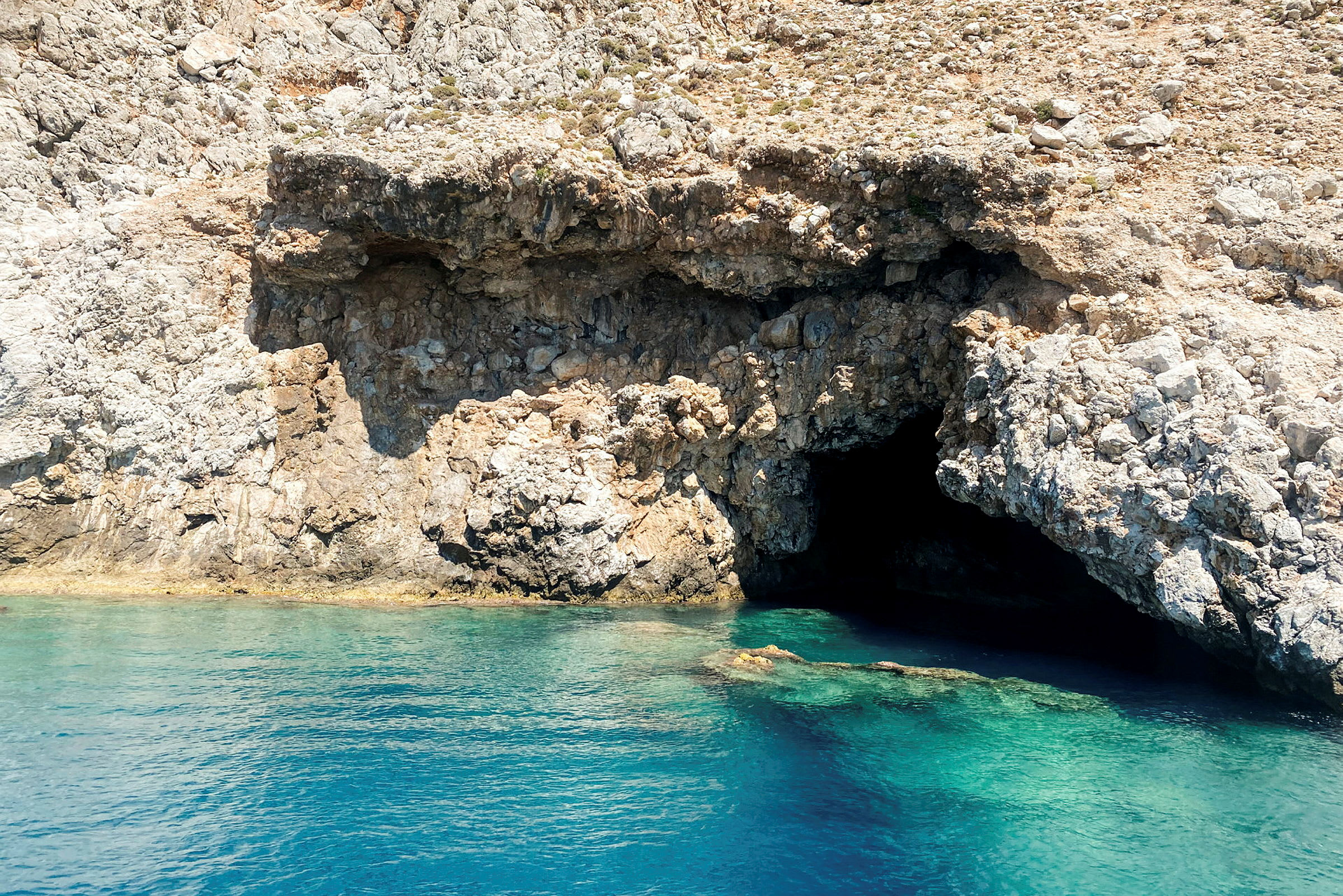 En klippa med en grotta vid havet. (AI-genererad text)