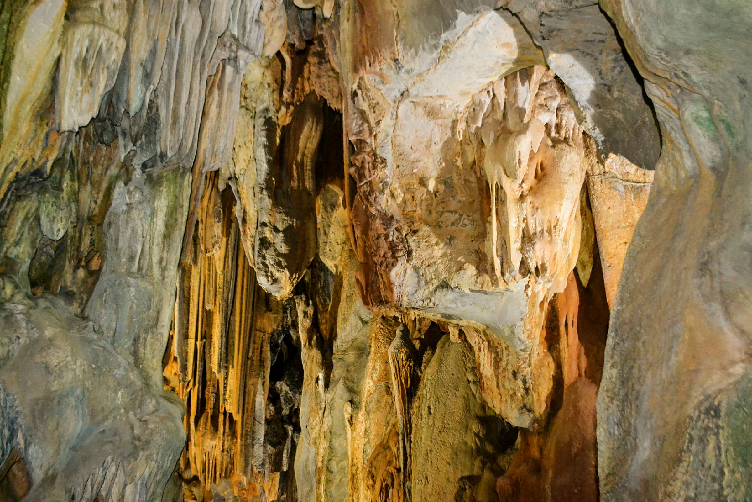 Bild av en grotta med stalaktiter och stalagmiter på väggarna. (AI-genererad text)